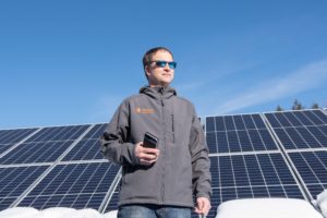 Nils Behn, CEO and President of Aegis Renewable Energy, stands in front of solar panels at Kingsbury Companies in Waitsfield. Photo by Erica Houskeeper.
